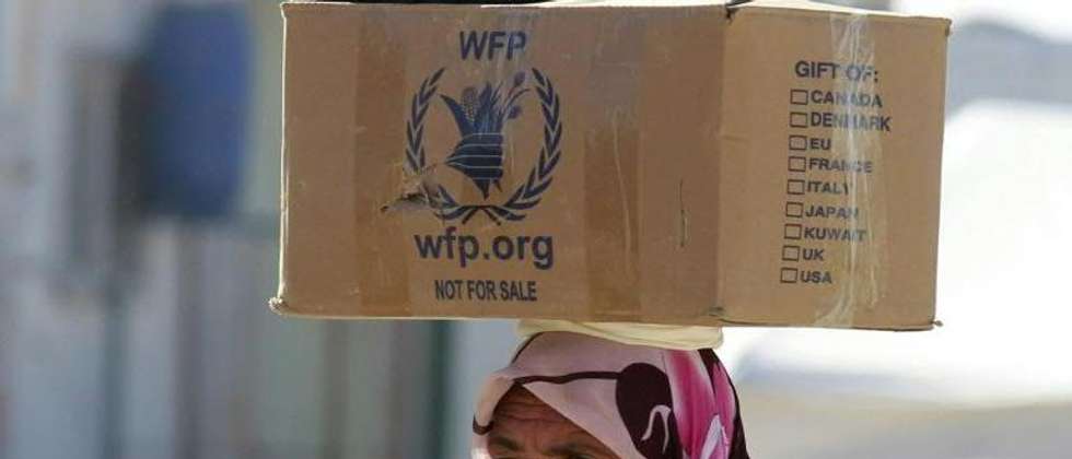 A Syrian refugee carries on her head a box distributed by the World Food Programme as she walks through the Zaatari refugee camp in Jordan, on January 24, 2014 ( Khalil Mazraawi (AFP) )