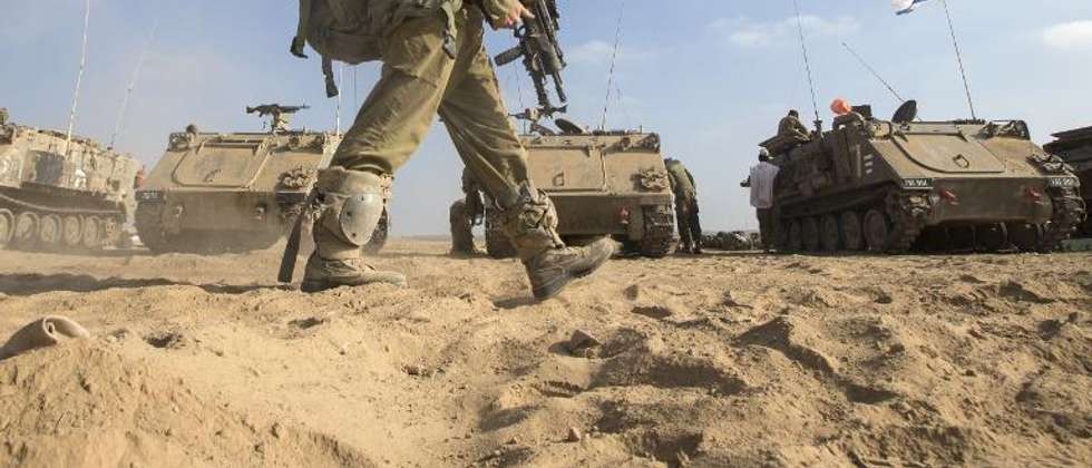 Un soldat israélien devant des véhicules blindés, le 1er août 2014 à la frontière avec la bande de Gaza ( Jack Guez (AFP) )