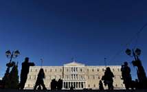 People walk past the Greek parliament in Athens on December 17, 2014 (Aris Messinis (AFP/File))