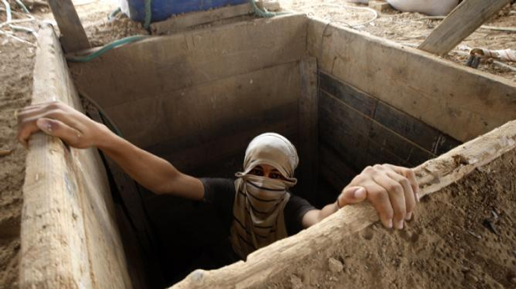 Un Palestinien émergeant d'un tunnel à la frontière entre Gaza et l'Egypte