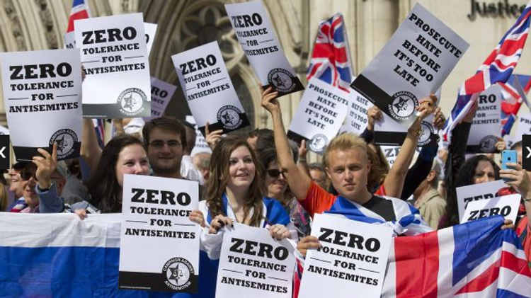 People hold placards and Israeli and Union flags outide the Royal Courts of Justice as Jewish groups rally in London on August 31, 2014.
