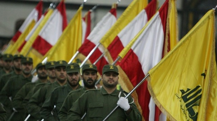 A picture taken on November 11, 2009, shows Hezbollah fighters, holding up Lebanese flags and the yellow flag of the militant Shia Muslim group, as they parade on the occasion of Martyr's Day in the southern suburbs of Beirut.