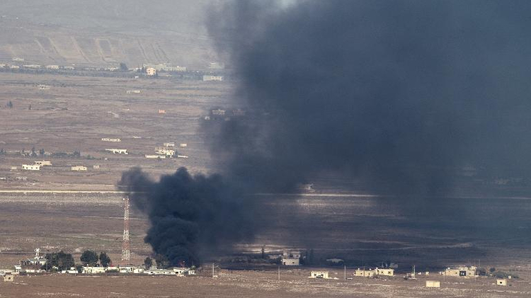 Smoke rise from the Syrian village of Quneitra, seen from the Israeli-occupied Golan Heights, from fighting between forces loyal to President Assad and rebels over the control of the Quneitra border crossing, August 27, 2014