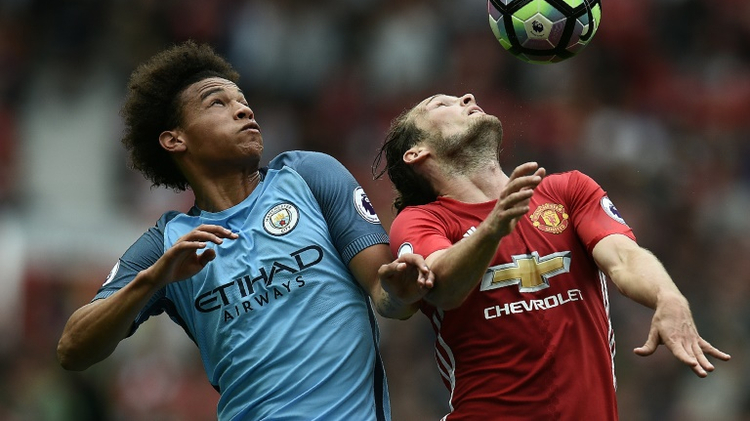 Manchester City's Leroy Sane (L) fights for the ball with Manchester United's Daley Blind during their English Premier League match, at Old Trafford, on September 10, 2016