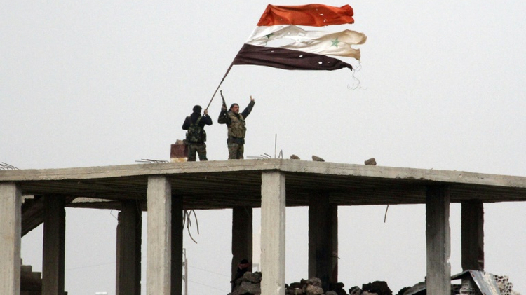 Syrian government forces wave the national flag in Deir al-Adas in the Daraa province on February 11, 2015 after President Bashar al-Assad's army, backed by Hezbollah and Iranian officers, pushed rebels out of the area (Illustrative)