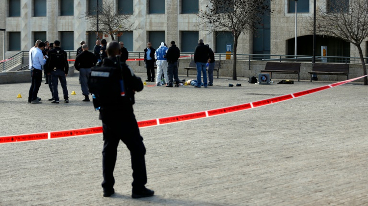 Israeli forensic police stand next to the body of a Palestinian assailant who was shot dead following a reported attack on December 26, 2015, near Jerusalem's Old City