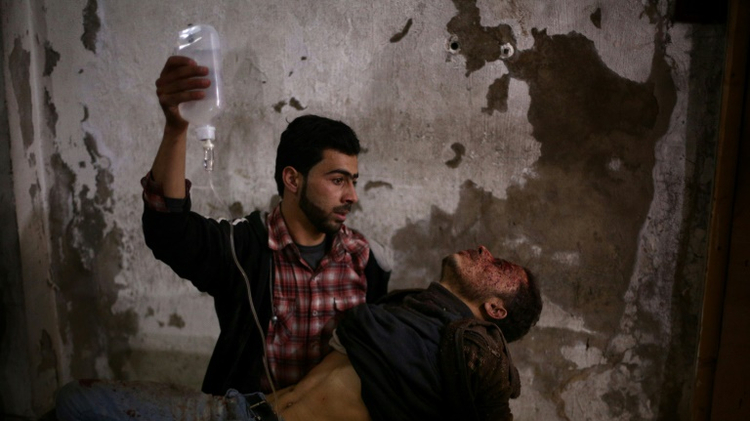 An wounded Syrian man receives treatment at a makeshift hospital in the rebel held area of Douma, north east of the capital Damascus, following reported air strikes by forces loyal to President Bashar al-Assad on February 2, 2015