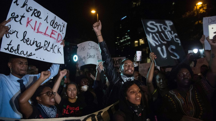 Protesters chant slogans during a march in Charlotte, North Carolina, on the third night of protests following the fatal police shooting of a black man