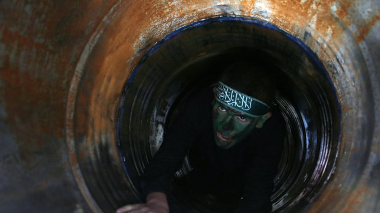 A Palestinian youth crawls in a tunnel during a graduation ceremony for a training camp run by the Hamas movement on January 29, 2015 in Khan Yunis, in the southern Gaza Strip