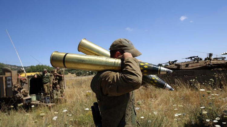 Un soldat israélien amène des muntions à un char positionné à un point de contrôle à la frontière entre Israël et la Syrie, sur le plateau du Golan, le 22 juin 2014