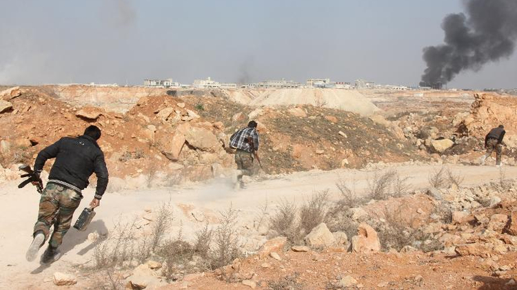 Rebel fighters run for cover during reported battles against pro-government forces in February 2014, in the Sheikh Najjar district on the outskirts of the northern Syrian city of Aleppo