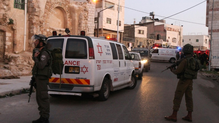 Des ambulances et des membres des forces de sécurité israéliennes, le 14 février 2016 à Hébron en Cisjordanie