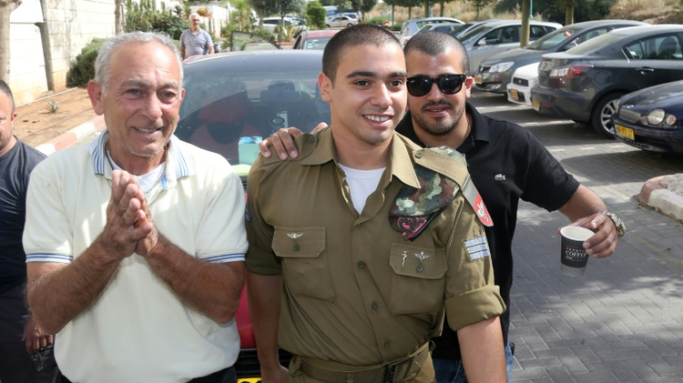 Elor Azria (C), an Israeli soldier recently charged with manslaughter after shooting a wounded Palestinian assailant in the head, arrives home in the central city of Ramle on April 22, 2016 after he was freed briefly to mark the start of Passover
