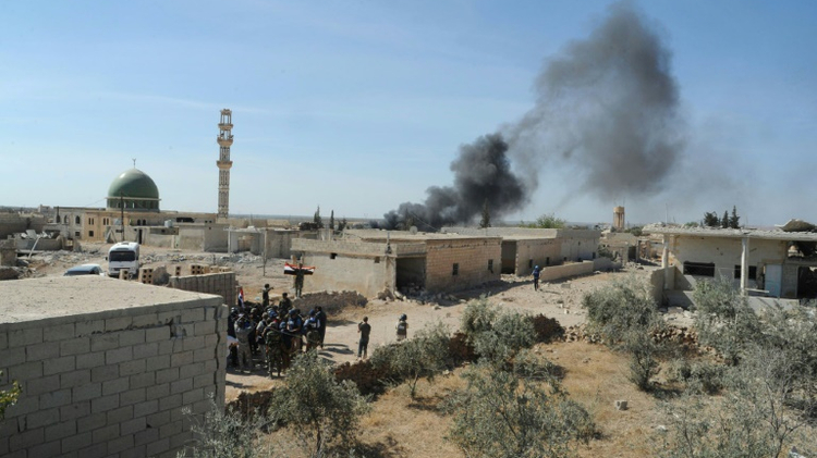Smoke billows from Atshan after pro-regime forces captured the village as part of their offensive across central Hama province, on October 11, 2015