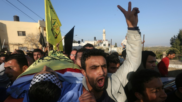 Palestinians mourners carry the bodies of teenagers Nihad Waked and Fuad Waked after they were shot dead by Israeli security forces as they reportedly fired on Israeli soldiers on February 14, 2016 during their funeral in the village of Araka