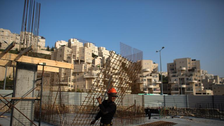 A Palestinian labourer works on a new housing construction site in the Israeli settlement of Har Homa in east Jerusalem, on March 19, 2014