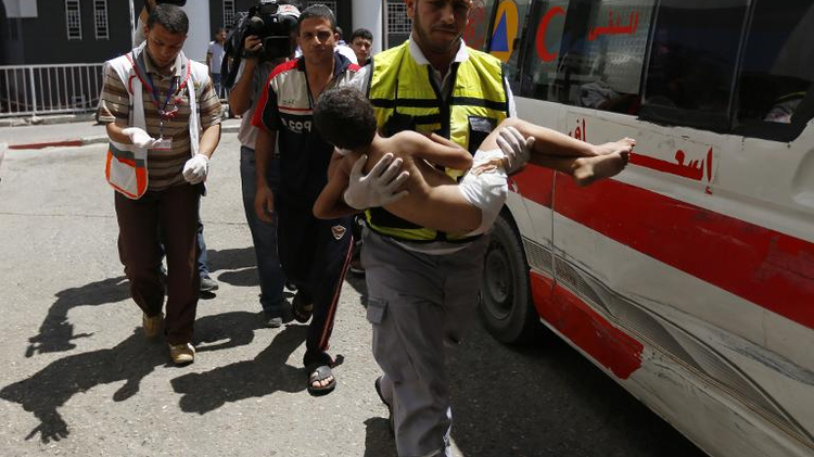 An emergency worker carries a child wounded in an Israeli air strike on the Sheikh Radwan area of Gaza City, as he arrives at the city's Al-Shifa hospital, on August 8, 2014