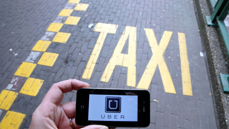 Le logo d'Uber affiché sur un smartphone pendant une manifestation de taxis à Bruxelles contre l'application, le 13 septembre 2015