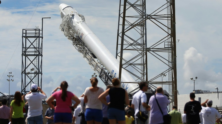 A SpaceX Falcon 9 rocket is raised into launch position at Cape Canaveral, Florida, in October 2012