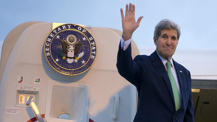 US Secretary of State John Kerry waves as he boards his plane at Paris' Orly Airport en route to Vienna, on October 15, 2014