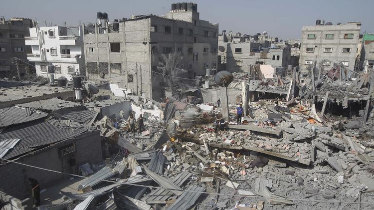 Palestinians inspect the wreckage of a building which was hit in an Israeli strike on the southern gaza town of Rafah, on August 2, 2014