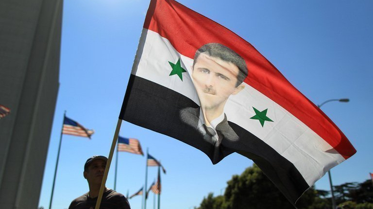 A Syrian supporter of President Bashar al-Assad waves a flag during a rally in Los Angeles, on September 7, 2013