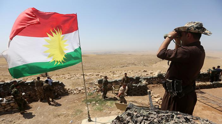 Iraqi Kurdish Peshmerga fighters take position to monitor the area from their front line post in Bashiqa, a town 13 kilometers north-east of Mosul on August 16, 2014.