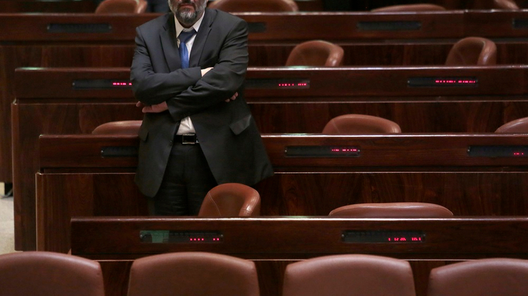 Israeli religious Shas party leader Aryeh Deri standing in the Knesset (Parliament) plenum in Jerusalem on 08 December 2014.