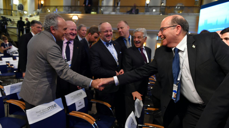 Israeli Defense Minister Ya'alon shakes hands with Saudi Prince Turki al-Faisal