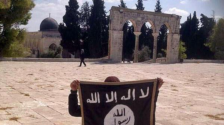 A boy holding up the Islamic State flag on the Temple Mount in Jerusalem in 2014