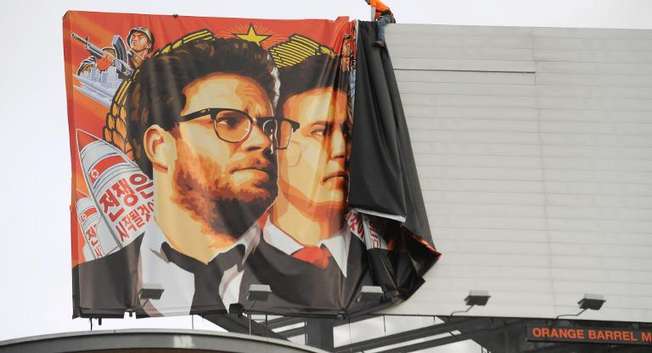 Workers remove a poster-banner for "The Interview" from a billboard in Hollywood, California, December 18, 2014 ( Michael Thurston (AFP/File) )