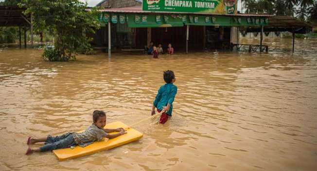 Children play in floodwaters near their house in Chempaka, near Kota Bahru on December 28, 2014 ( Mohd Rasfan (AFP) )