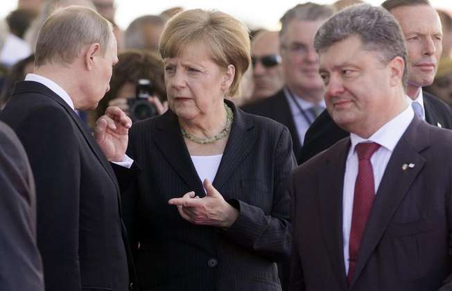 La chancelière allemande Angela Merkel (c), le président russe Vladimir Poutine (g) et le président élu ukrainien Petro Porochenko, le 6 juin 2014 à Ouistreham (Saul Loeb (AFP))
