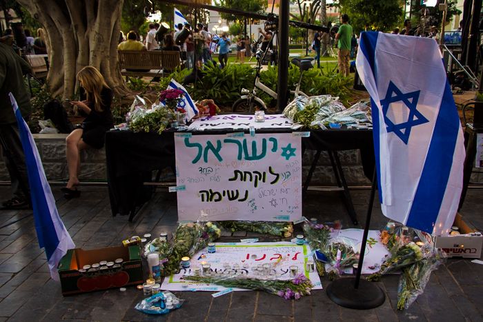 Mourners lay down flowers and lie candles at the site of the terror attack in which two Palestinian gunmen killed four patrons of the Sarona market in Tel Aviv a day earlier, June 9 2016 Jessi Satin/i24news