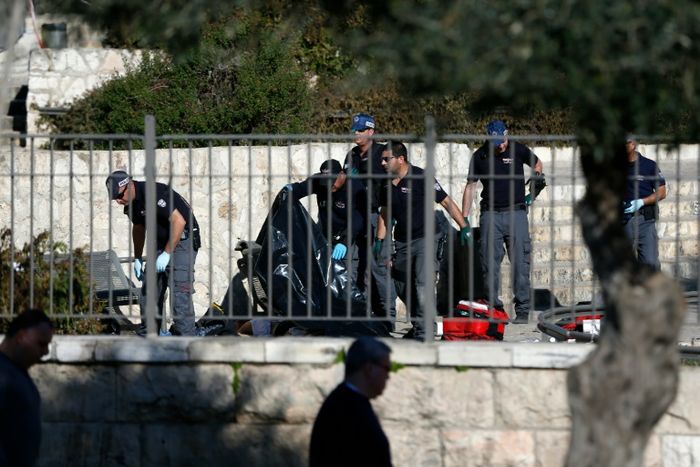 Des policiers israéliens autour du corps d'un Palestinien tué après des attaques au couteau et à l'arme à feu, le 3 février 2016 à Jérusalem AHMAD GHARABLI (AFP)