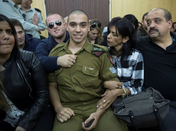 Le soldat israélien Elor Azaria (c), avec ses proches au tribunal militaire de Tel Aviv dans l'attente de son jugement, le 4 janvier 2017 Heidi Levine (POOL/AFP)