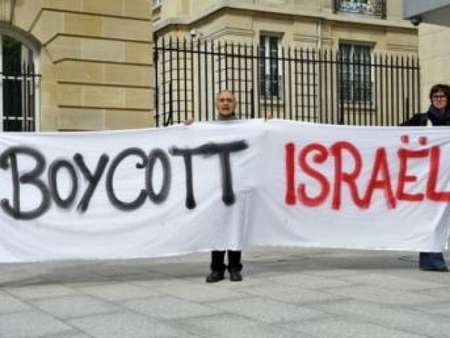 An anti-Israel activists holds up a banner calling for the boycott of Israel - PHOTO: AFP. PHOTO: AFP.