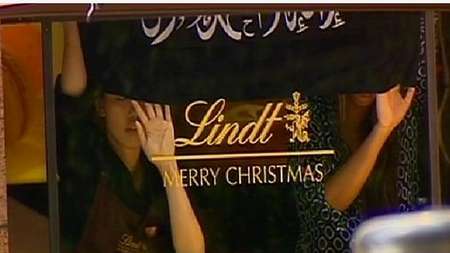 Hostages hold IS flag in a Sydney coffee house, December 15, 2014 - Ynet Ynet