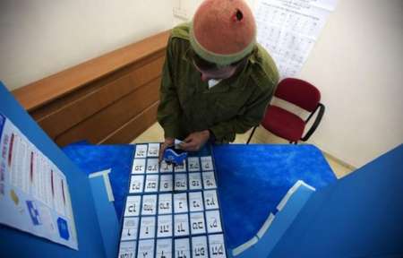 Un Israélien choisit son bulletin de vote dans l'isoloir - AFP AFP