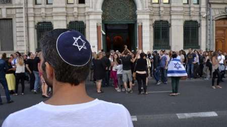 Un homme portant une kippa, regarde les gens prendre part à une manifestation appelée par le Conseil représentatif des institutions juives de France le 31 Juillet 2014 devant la synagogue de Lyon (Crédit : AFP / ROMAIN Lafabregue) - AFP AFP