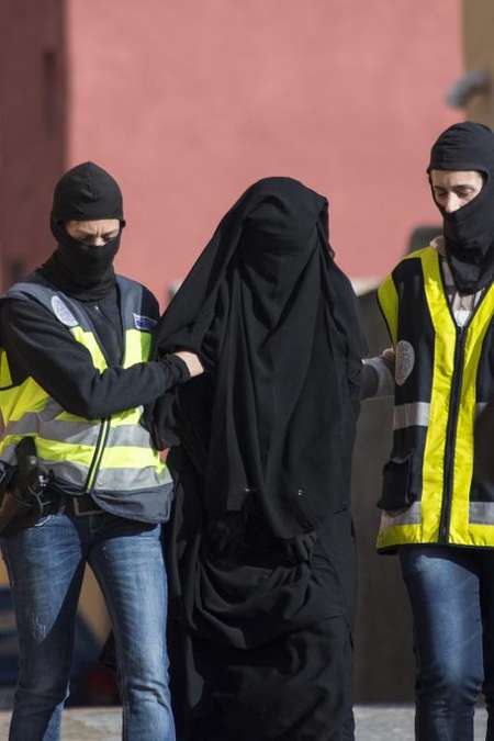 Spanish police escort a 20-year-old Abaya clad woman in Melilla on December 16, 2014 during a series of arrests for suspected recruitment of young women via the Internet to join Islamic State militants fighting in Iraq and Syria - Jesus Blasco de Avellaneda (AFP/File) Jesus Blasco de Avellaneda (AFP/File)