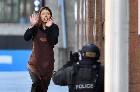 One of the hostages runs towards police after leaving a cafe where a gunman is holding an unknown number of people in the central business district of Sydney on December 15, 2014 - Saeed Khan (AFP) Saeed Khan (AFP)