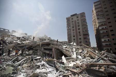 Palestinians look through the rubble of a 12-storey apartment building in Gaza City on August 24, 2014 that collapsed after it was hit by an Israeli air strike the day before - Mahmud Hams (AFP/File) Mahmud Hams (AFP/File)