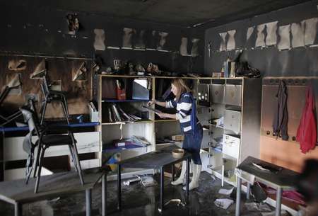 Une femme constate dans une salle de classe les dégâts de l'incendie criminel de l'école à Jérusalem qui a également été taguée d'inscriptions anti-arabes, le 30 novembre 2014 - Ahmad Gharabli (AFP) Ahmad Gharabli (AFP)