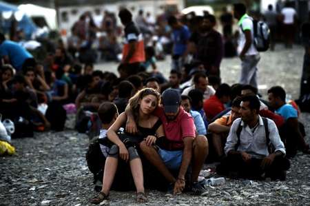 A Syrian couple waits with other migrants for the train near a train station at the F.Y.R. of Macedonia's village of Gevgelija on August 29, 2015 ( Aris Messinis (AFP/File) )