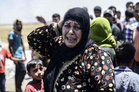 Une Syrienne en pleurs alors que la ville syrienne de Tal Abyad est bombardée, le 14 juin 2015, à la frontière avec la Turquie - BULENT KILIC (AFP) BULENT KILIC (AFP)