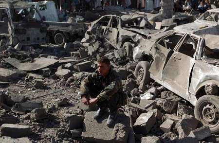 Un membre des forces de sécurité yémenites assis parmi les débris provoqués par un raid aérien saoudien sur un immeuble près des l'aéroport de Sanaa, le 26 mars 2015 - Mohammed Huwais (AFP) Mohammed Huwais (AFP)