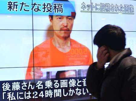 Le portrait de Kenji Goto tenant la photo du pilote jordanien capturé par l'EI apparaît sur un écran géant le 28 janvier 2015 à Tokyo lors d'un reportage de la TV japonaise - Kazuhiro Nogi (AFP) Kazuhiro Nogi (AFP)