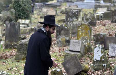Patrick Hertzog (AFP) - Un membre de la communauté juive observe les tombes profanées du cimetière Sarre-Union, dans le Bas-Rhin, le 17 février 2015 ( Patrick Hertzog (AFP) ) Un membre de la communauté juive observe les tombes profanées du cimetière Sarre-Union, dans le Bas-Rhin, le 17 février 2015 ( Patrick Hertzog (AFP) )