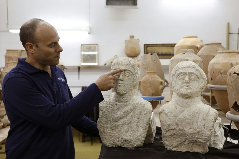 Israeli archaeologist Eitan Klein of the Israel Antiquities Authority shows off two late Roman busts unearthed near the ancient city of Beit Shean following a chance find by a woman walker -- Gali Tibbon (AFP)